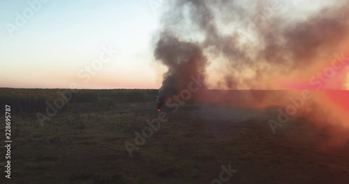 clouds of smoke come from an object burning in the field