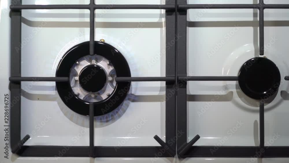 Gas stove burner cooktop top view. Heating up water in stainless steel whistling kettle on gas stove. Gas stove burner cooktop top view. Heating up water in stainless steel whistling kettle on gas stove.