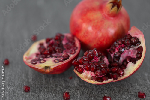 food, fruits and healthy eating concept - close up of pomegranate on stone table
