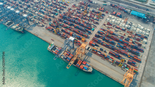 Container ship in export and import business and logistics. Shipping cargo to harbor by crane. Water transport International. Aerial view and top view. © MAGNIFIER