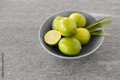 food  healthy eating and vegetarian concept - close up of whole limes in bowl