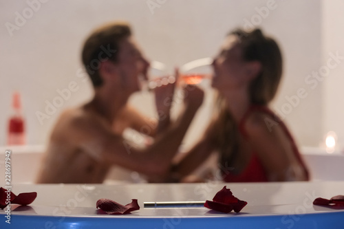 Romantic ouple drinking champagne in jacuzzi photo