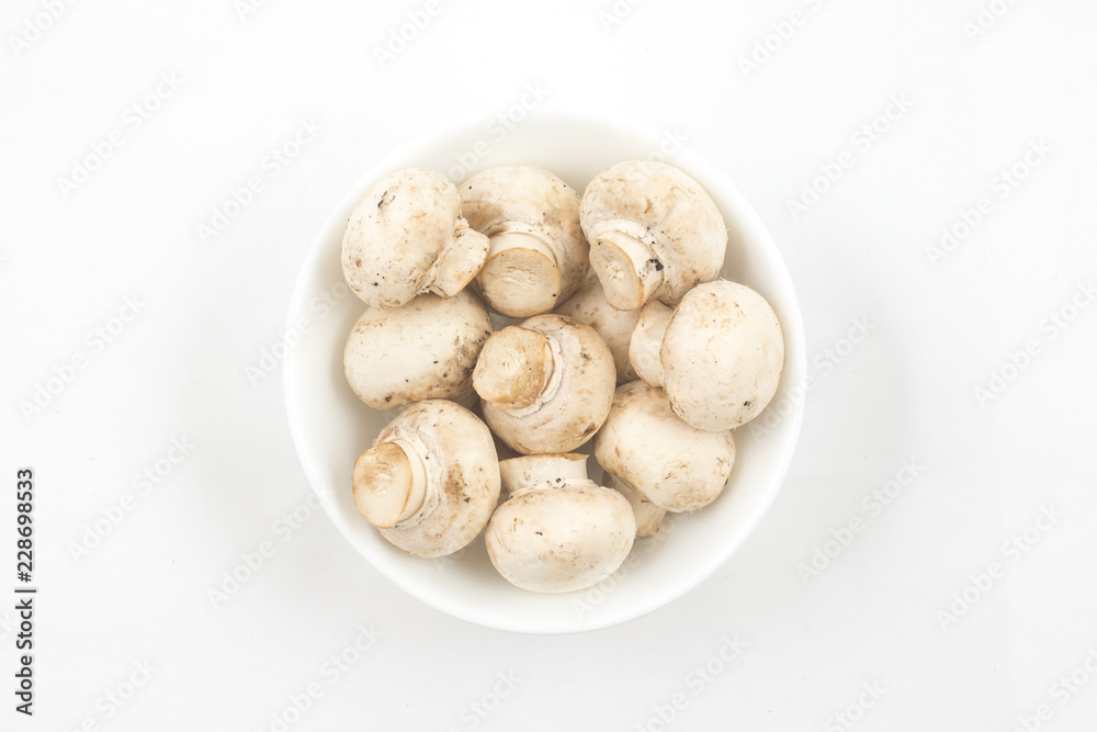 Mushroom champignon in a bowl isolated on white background