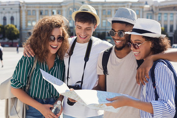 Group of friends walking through the city with map
