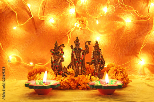 hindu god ram, sita, laxman, hanumaan statue with decorative lights, oil clay lamps and flowers for diwali celebration
