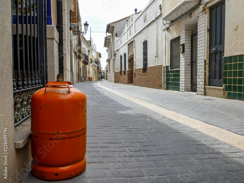 Orange gas cylinder on a quiet street