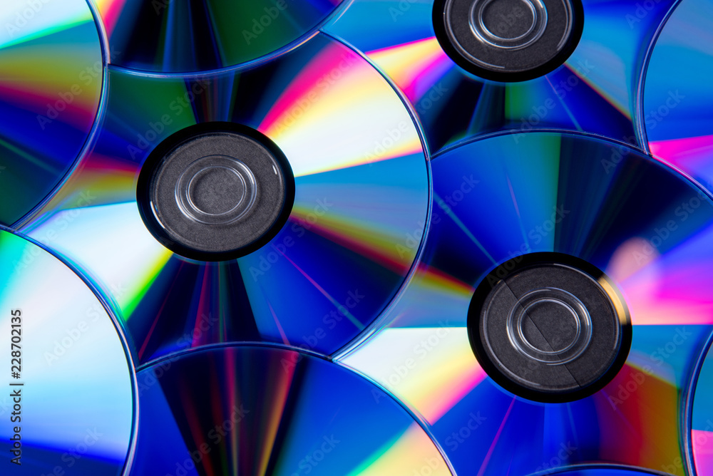 Many musical compact discs with a rainbow spectrum of colors as a bright background