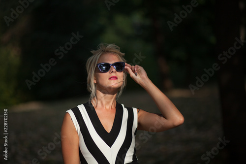 beautiful blonde woman in the autumn forest at sunset