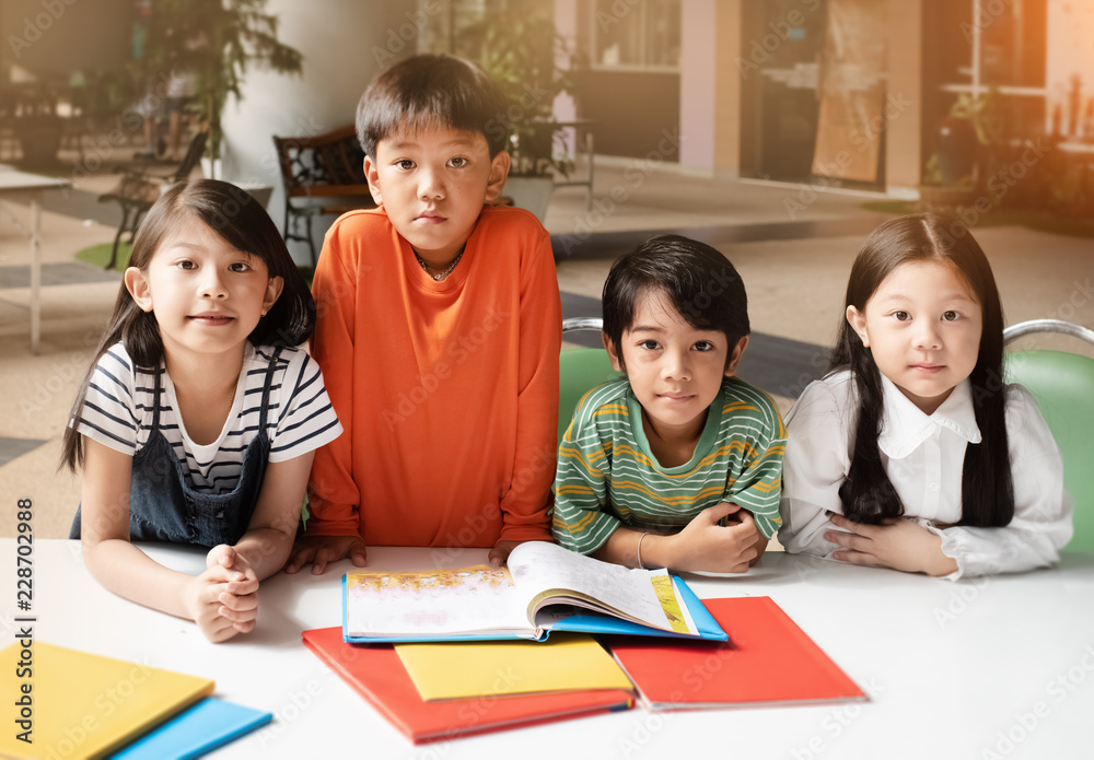 The children opened book,prepare for read together,warm light tone,blurry light design background The children opened book,prepare for read together,warm light tone,blurry light design background