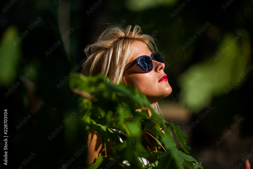 beautiful blonde woman in the autumn forest at sunset