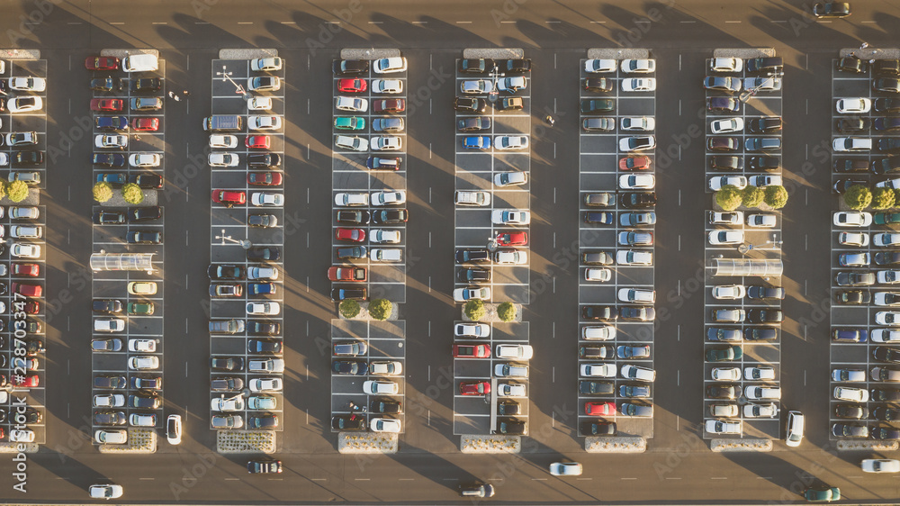 Top down view from drone on mall parking with many cars.