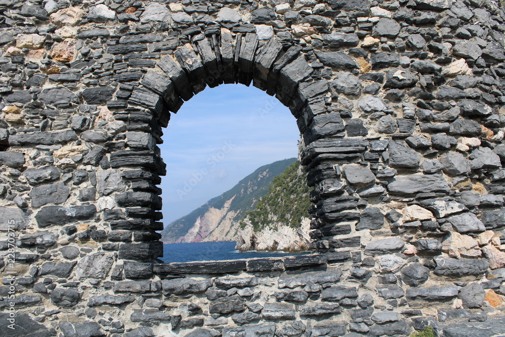 Fototapeta premium Mura in pietra con finestra ad arco sul mare