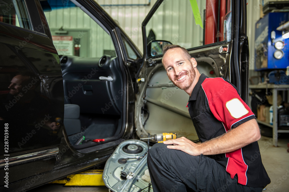 handsome mechanic based on car in auto repair shop handsome mechanic based on car in auto repair shop
