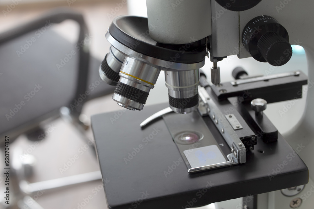 Close-up shot of examining test sample under the microscope in laboratory.
