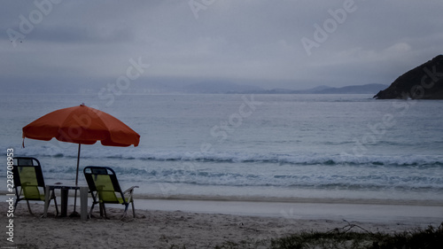 Chairs and umbrella at the edge of the beach