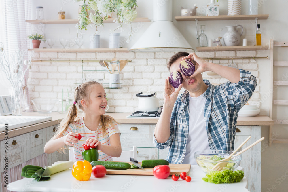 Cute girl and her dad having fun while cooking in kitchen Cute girl and her dad having fun while cooking in kitchen