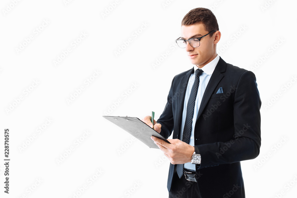 business, a man with a serious face, writing on a tablet on a blank sheet. Businessman in a suit or businessman signs a document on a white background. business, a man with a serious face, writing on a tablet on a blank sheet. Businessman in a suit or businessman signs a document on a white background.