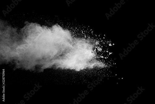 Explosion of white dust on black background. photo