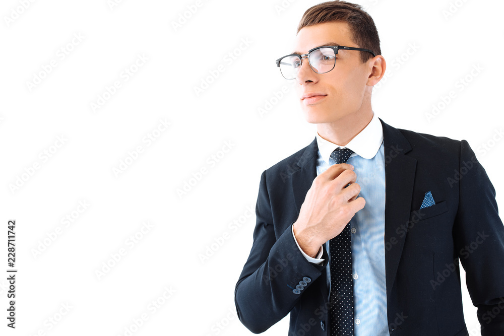 A successful businessman wearing glasses and a suit, straightens his tie and posing on an isolated white background A successful businessman wearing glasses and a suit, straightens his tie and posing on an isolated white background