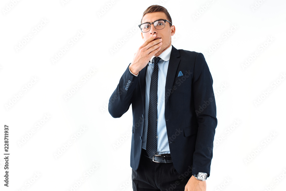 Businessman in glasses and suit, amazingly shocked by big eyes and open mouth, isolated on white background