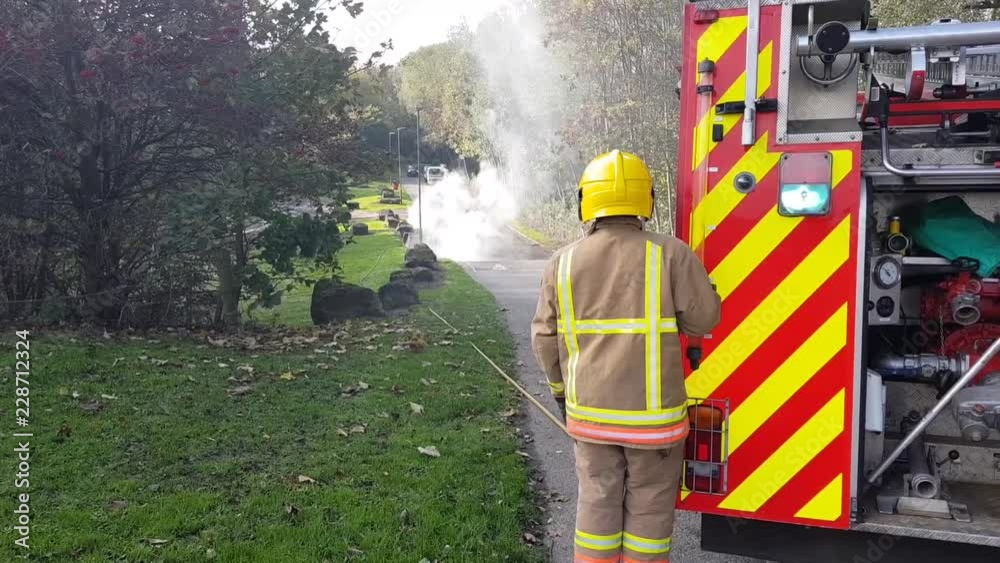 fire brigade dealing with burned out car