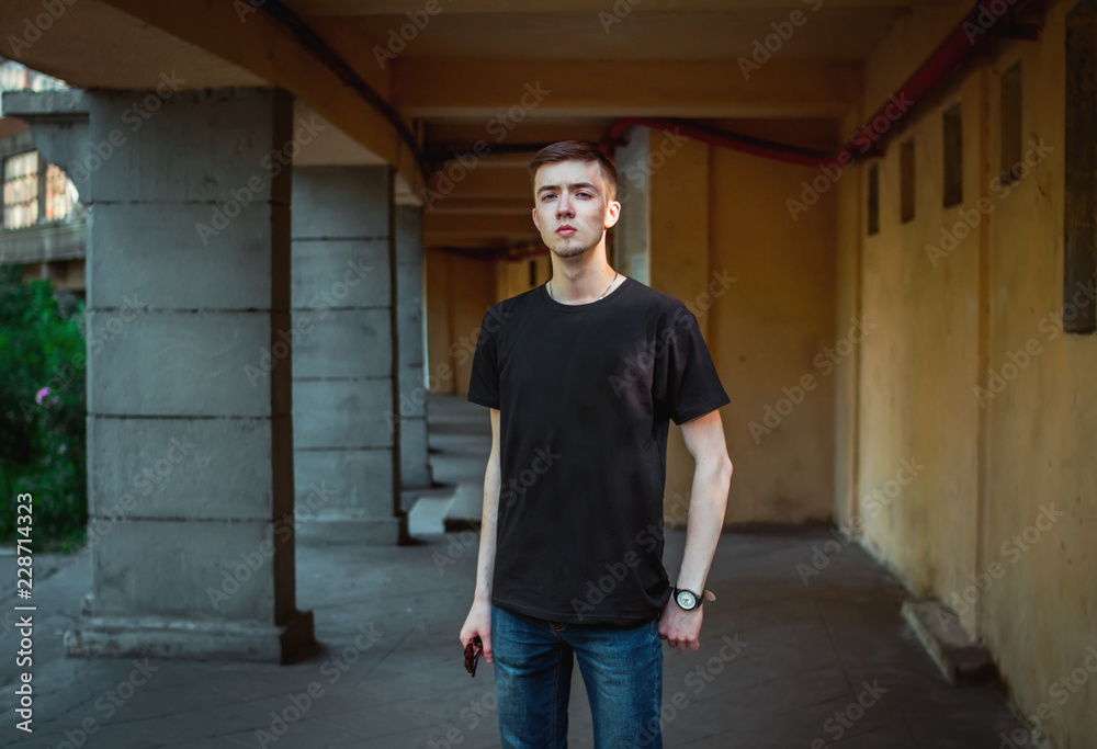 Portrait of sad and pensive handsome young man, wearing casual clothing standing near old building with columns Portrait of sad and pensive handsome young man, wearing casual clothing standing near old building with columns
