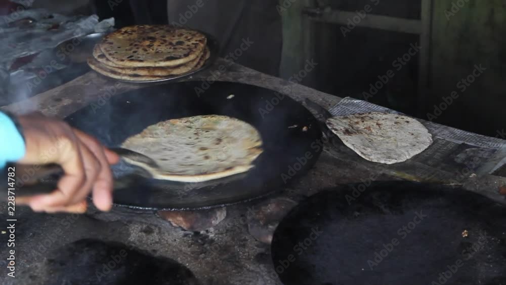 Medium shot of man frying paratha on frying pan Medium shot of man frying paratha on frying pan