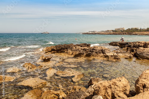 Cyprus is a fisherman on the coast of the Mediterranean sea, on the horizon a yacht © Дмитрий 