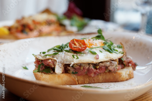 Sandwich with beef tartar and fried egg