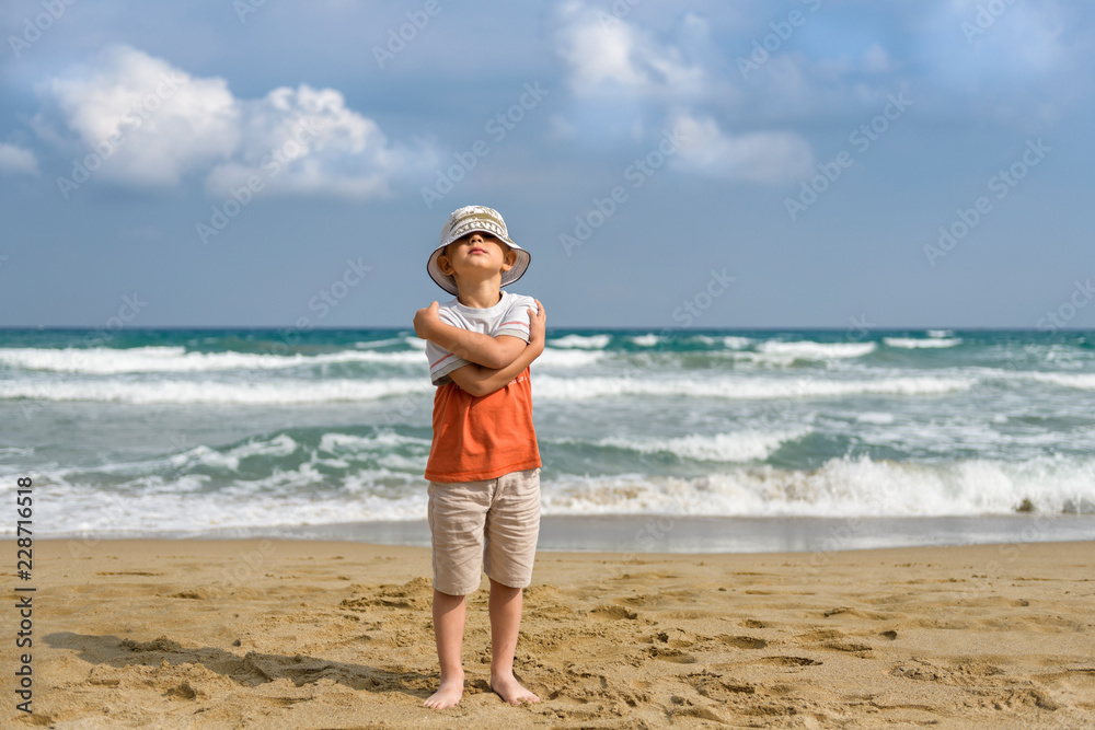 little boy on the beach playing with sand