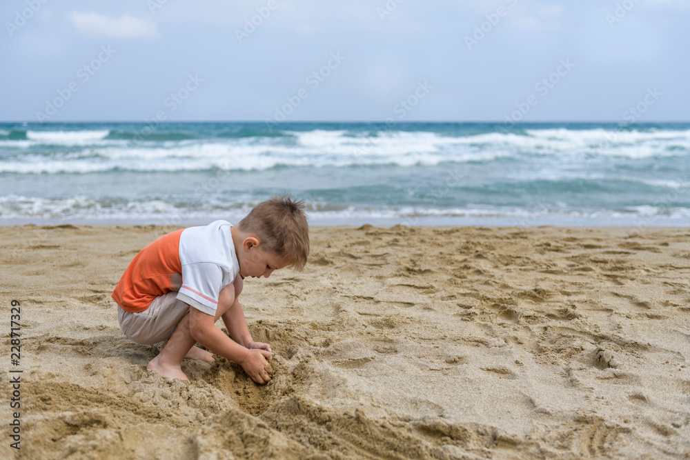 little boy on the beach playing with sand little boy on the beach playing with sand