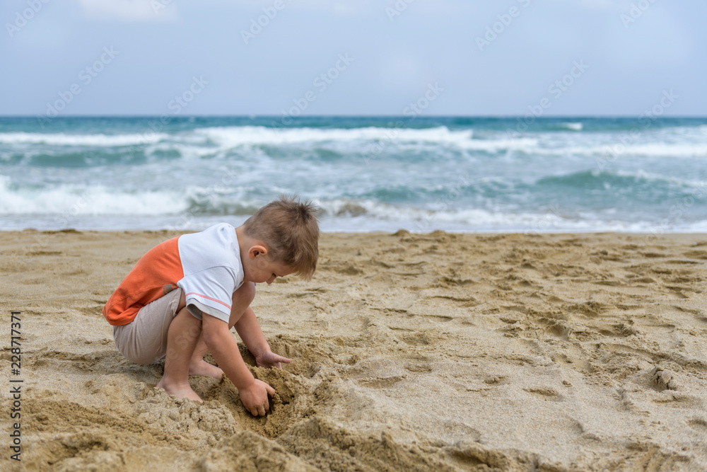 little boy on the beach playing with sand little boy on the beach playing with sand