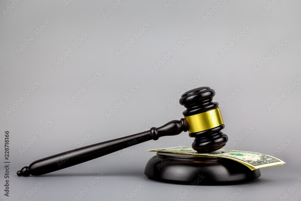 Judges gavel on dollar with gray background Judges gavel on dollar with gray background