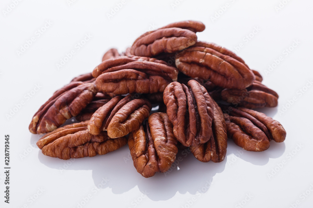 delicious pecan nuts on a white acrylic background delicious pecan nuts on a white acrylic background