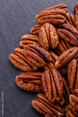delicious pecan nuts on a dark stone background