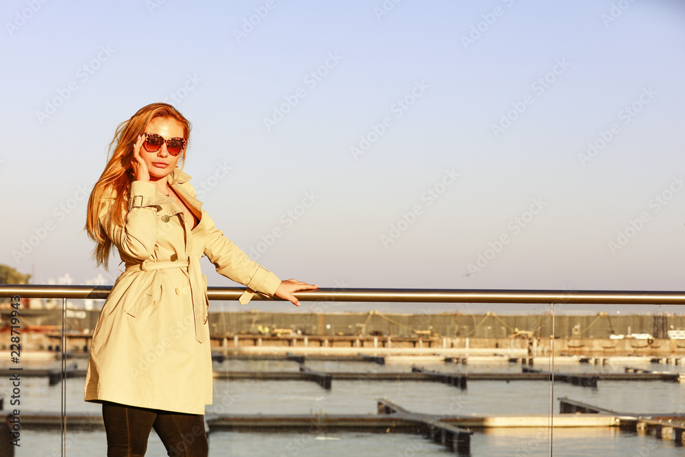 Slim young blond woman and autumn time. City background and golden sunset time. Slim young blond woman and autumn time. City background and golden sunset time.