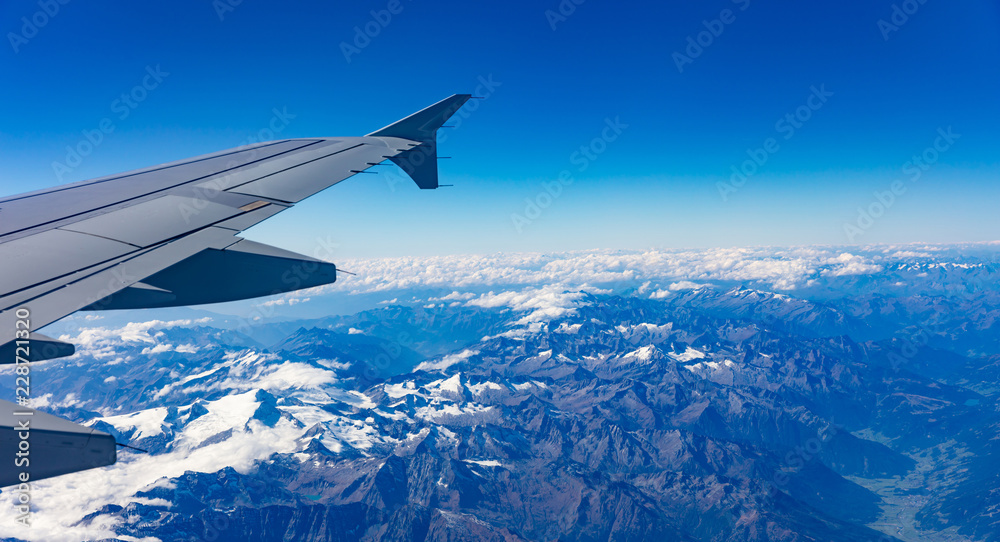 Mountains and blue sky. View out of an airplane window.