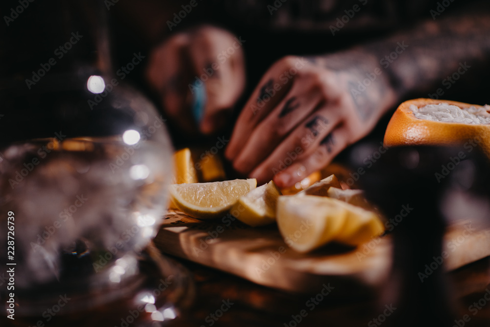 The process of cooking shisha, hookah bowl.Fruit in ice shaking.Citrus fruit for Shisha.Tattooed hands The process of cooking shisha, hookah bowl.Fruit in ice shaking.Citrus fruit for Shisha.Tattooed hands