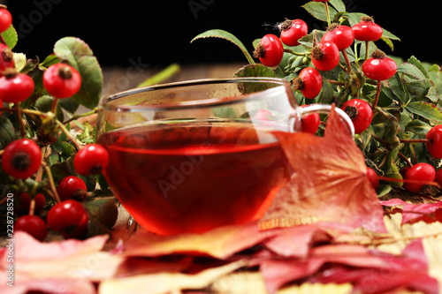 Tea. cup of herbal Dog rose tea with bunch branch Rosehips, types Rosa canina hips. Medicinal plants and herbs composition.