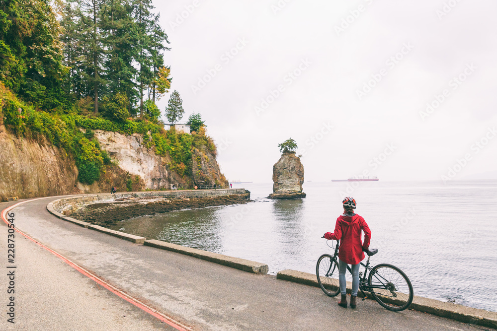 Naklejka premium Vancouver cyclist biking woman on bike path around Stanley Park, famous tourist activity in British Columbia, Canada.