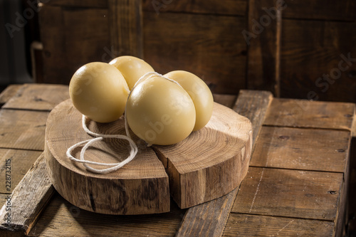 Gourmet italian cheese scamorza on wooden board on dark background