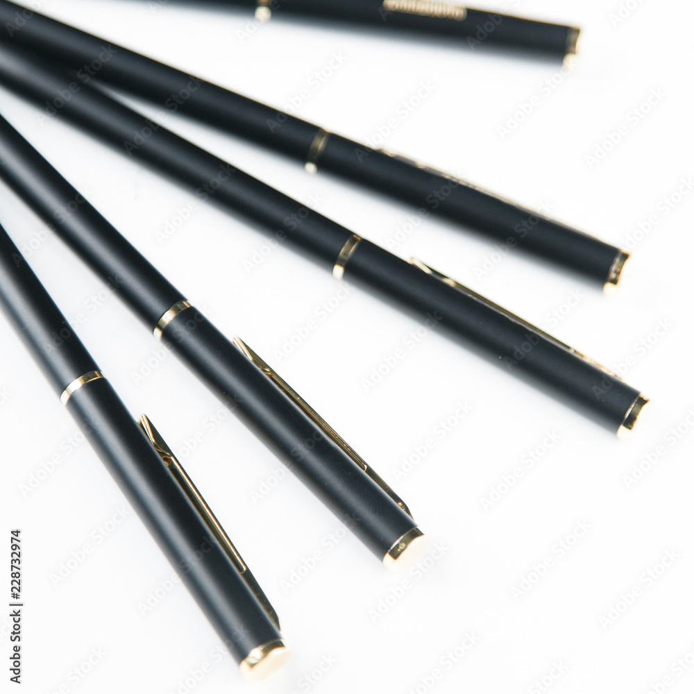 Notepad and pen on white background, carved. Minimalism, a set of pens. Details and macro, close view. Notepad and pen on white background, carved. Minimalism, a set of pens. Details and macro, close view.