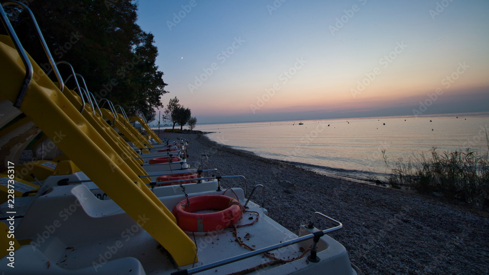 Tretboote am Strand bei Sonnenuntergang