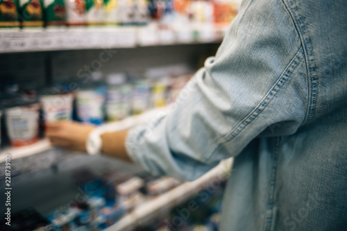 Female hand taking jar from market shelves blurred close-up