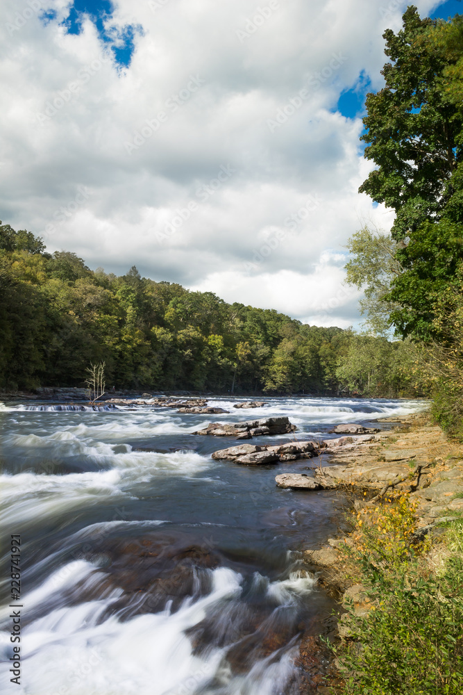 Obraz premium The Youghiogheny River as it flows through Ohiopyle State park on an early autumn day