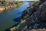 Valley of the Kamyanka River in the Dnipropetrovsk region, Ukraine. A herd of farm goats grazes in the rocks near the river.
