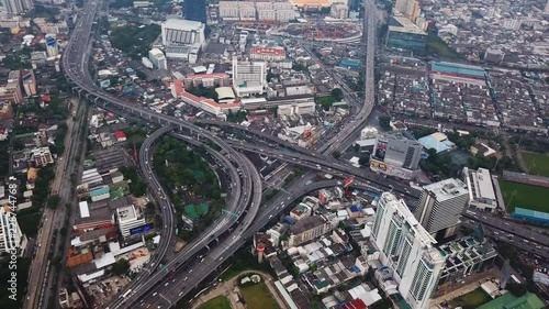 Cars driving on bridge roads shaped curve highways with skyscraper buildings. Aerial view of Expressway Bangna, Klong Toey in structure of architecture concept, Urban city, Bangkok, Thailand. photo