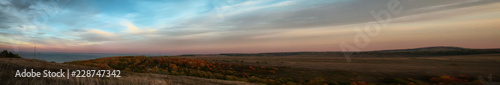 Panorama of hilly terrain with autumn forest near the Volga at sunset © tinkerfrost