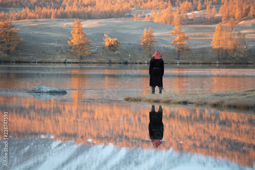 Mongolia Altai lake in autumn at sunrise - tree reflexion with man alone