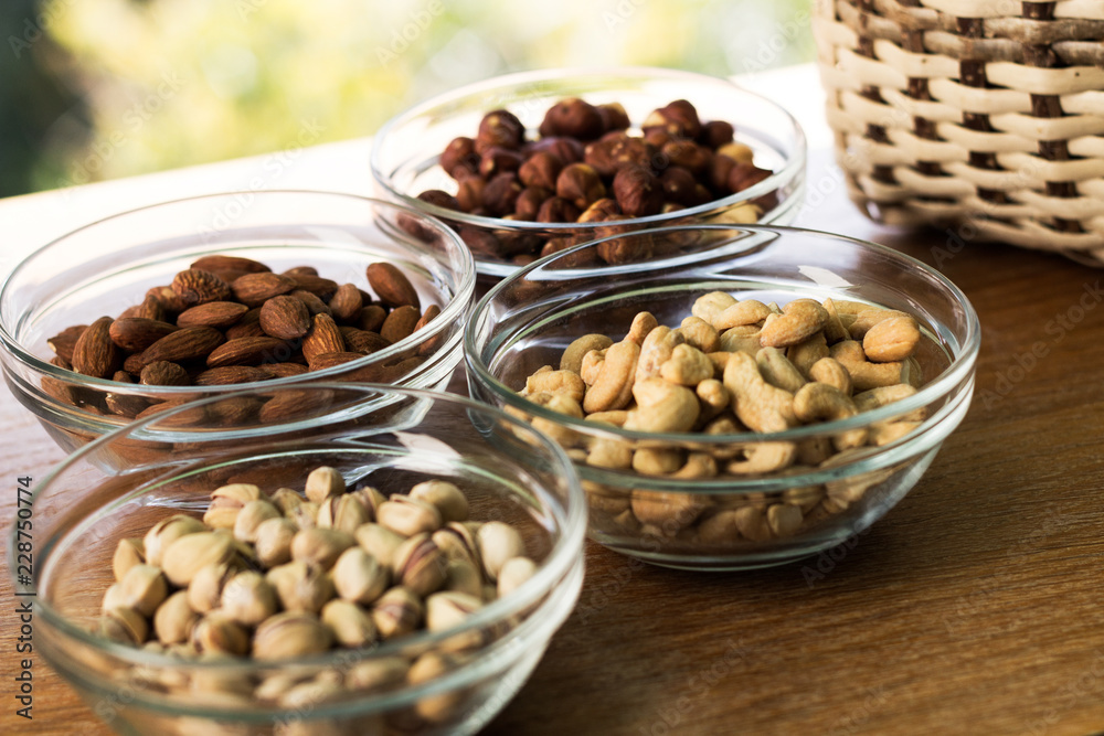 Assortment of mixed nuts and wicker basket on wood table background Assortment of mixed nuts and wicker basket on wood table background